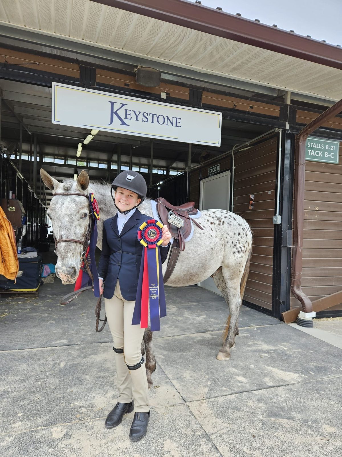 A student with championship ribbons under the Keystone sign